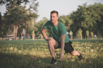 Guy stretching legs during warming-up for jogging