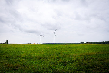 Fototapeta na wymiar Green field and two windmills