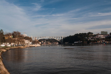 Obraz premium enjoying a beautiful early spring day next to the Douro River and the Arrabida Bridge at Porto City in Portugal