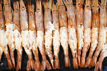 big prawns, seafood, vitamins. the process of cooking shrimp. the concept of cooking and healthy eating. a lot of fresh crayfish are lying on a plate, top view. seafood dish. tiger prawns with garlic