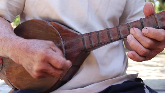 Old asian man playing thai wood mandolin , Northern local folk instruments in Thailand