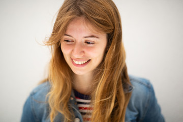 Close up smiling young woman looking down by white background