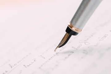Fountain pen on an ancient handwritten letter. Old story. Retro style.