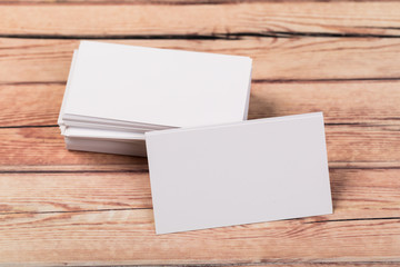 Photo of empty business cards on a light natural wooden background .. Template for identifier.