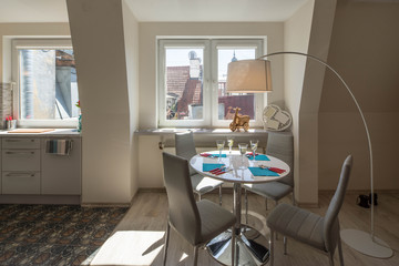 Light interior of kitchen with white walls and windows. Table and four chairs. Close-up.