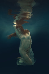 Portrait of a girl in a dress floating underwater