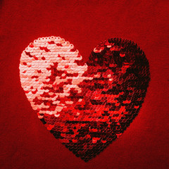 Red shiny heart shape embroidered with reversibile sequins on knit for Valentin day.