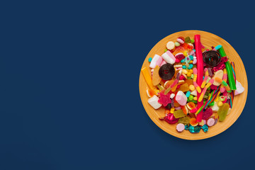 colored candies plate on dark blue background