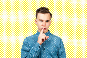 guy close mouth finger. White young man showing silence gesture, isolated.