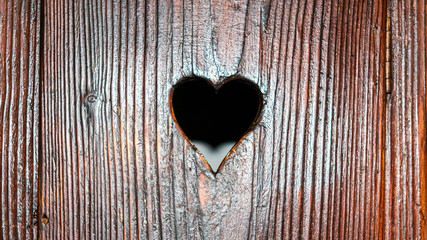 A heart carved in an old wooden door from a Romanian fortress symbolizing love on Valentine's Day. 16x9 ratio background wallpaper