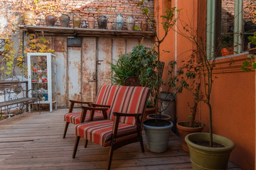 Fototapeta na wymiar cozy backyard with vintage chairs and potted plants , lifestyle and retro interior design inspiration concept