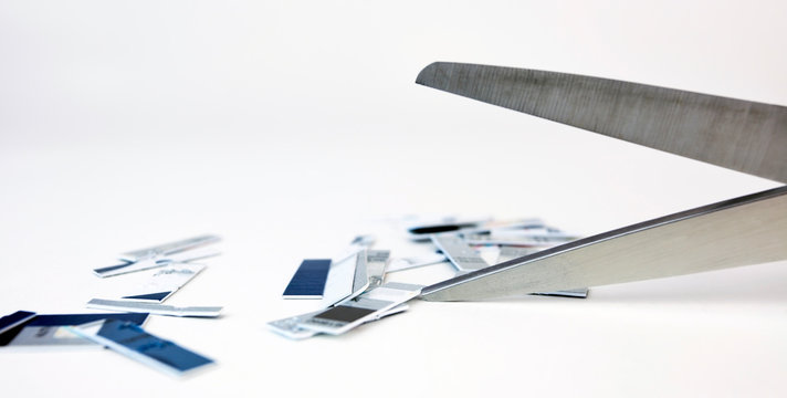 Credit Card Debt Concept With Card Pieces And Scissors.