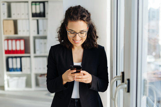 Woman reading a text message with a happy grin