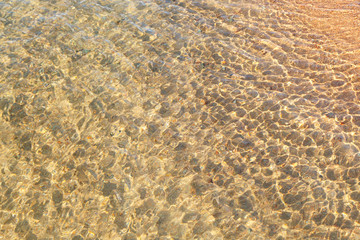 Fototapeta na wymiar Clear water texture in blue. Background of the ocean and the sea backlit by the sun. Natural water