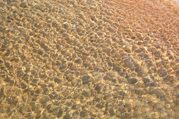 Fototapeta na wymiar Clear water texture in blue. Background of the ocean and the sea backlit by the sun. Natural water