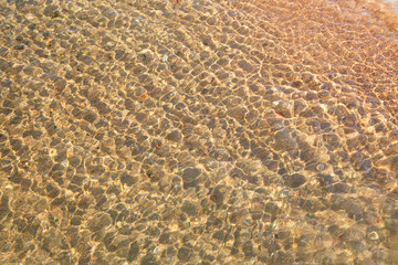 Clear water texture in blue. Background of the ocean and the sea backlit by the sun. Natural water