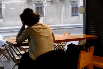 young woman sitting at the table in cafe