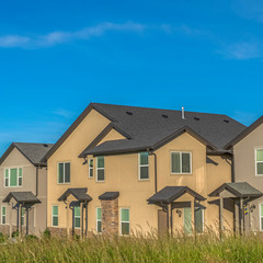 Square frame Exterior view of multi storey homes with balconies and porticos against blue sky