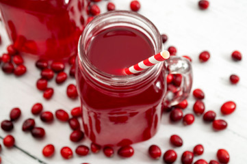 Beverages rich in antioxidants, healthy diet and natural drinks conceptual idea with glass jar with cranberry juice and raw cranberries surround the drink isolated on white background