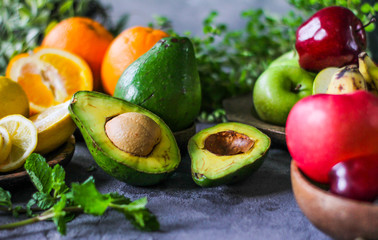 Naklejka na ściany i meble Photo of ripe organic avocado on dark background. Wooden table. Nutritious Fruit. Healthy food concept. Tropical vegetable. Green fruit. Image.