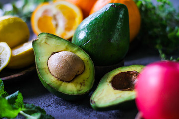 Photo of ripe organic avocado on dark background. Wooden table. Nutritious Fruit. Healthy food concept. Tropical vegetable. Green fruit. Image.