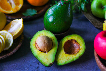 Photo of ripe organic avocado on dark background. Wooden table. Nutritious Fruit. Healthy food concept. Tropical vegetable. Green fruit. Image.