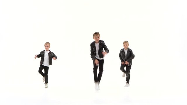 Kids are dancing a modern dance on the white background in black leather jackets and jeans