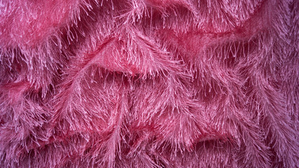 Pink knitted shaggy fabric. Randomly folded.