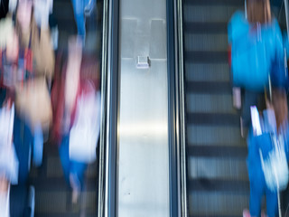 People rush on escalator motion blurred