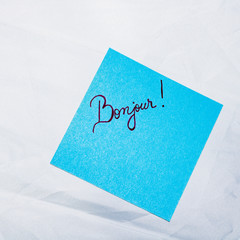 Text Bonjour on post it. Writing on colorful sticky note. Bucharest, Romania, 2020. © Vlad Ispas
