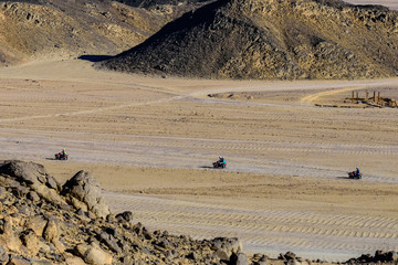 People driving quad bikes during safari trip in Arabian desert not far from the Hurghada city, Egypt