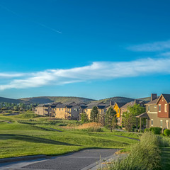 Square Houses around a golf course with scenic background of mountain and blue sky