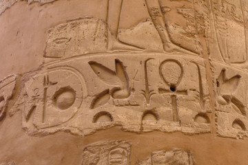 Egyptian ancient hieroglyphs on the stone wall. Closeup of the symbol of eternal life ankh