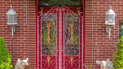 Pano frame Green awning over a beautiful red door with decorative wrought iron gate