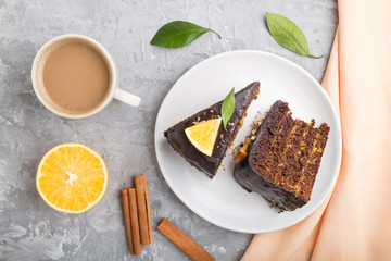 Homemade chocolate cake with orange and cinnamon with cup of coffee on a gray concrete background. top view.
