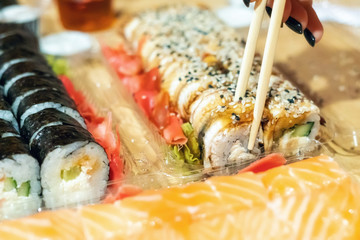 Food sushi roll, hand with chopsticks close-up
