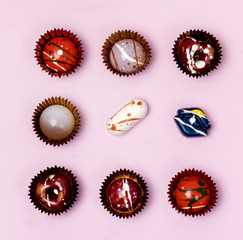 Luxury Bonbons Painted with Differents Colors on Pink background Beautiful and Exclusive Handmade chocolate Candy Square Flat Lay