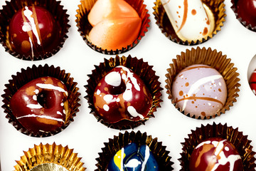 Close Up Luxury Bonbons Painted with Differents Colors in White Box on Pink background Beautiful and Exclusive Handmade chocolate Candy