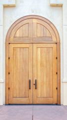 Obraz na płótnie Canvas Vertical Double arched wooden entrance door of exterior