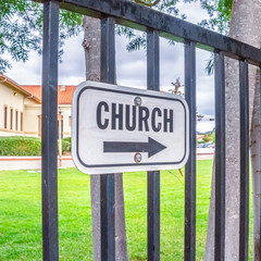 Square frame Church sign with arrow outdoors on a sunny day