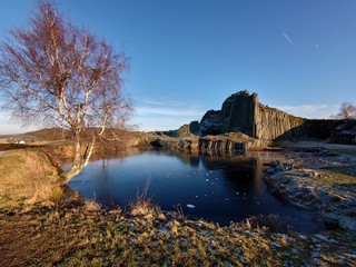 Fototapeta premium Beautiful view of landscape with basalt rock and lake - Kamenicky Senov (Herrenhausfelsen), Czech Republic