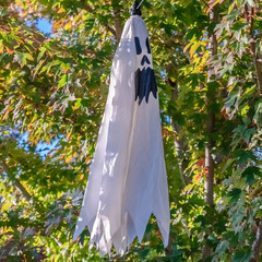 Square Hanging ghost halloween outdoor decoration on a sunny day