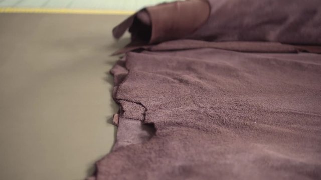 Brown pieces of leather in a rolls. Raw materials for manufacture of bags, shoes, clothing and accessories.