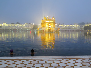 Two man taking ishnaan (morning cold bath) at Golden Temple (Harmandir Sahib or Darbar Sahib) in Amritsar, Punjab, India