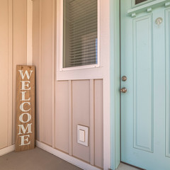 Square Green wooden front door with welcome sign