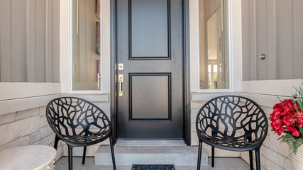 Panorama Two black chairs flanking an entrance door