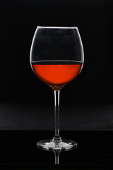 Glass, crystal glass of red wine with highlights on a dark background. Vertical
