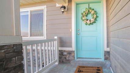 Panorama Wooden blue front door with wreath on a sunny day
