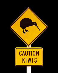 Caution kiwis, New Zealand iconic yellow road sign isolated on black background © Delphotostock