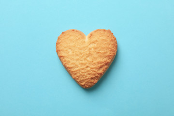 Obraz premium Heart shaped cookie on blue background, close up